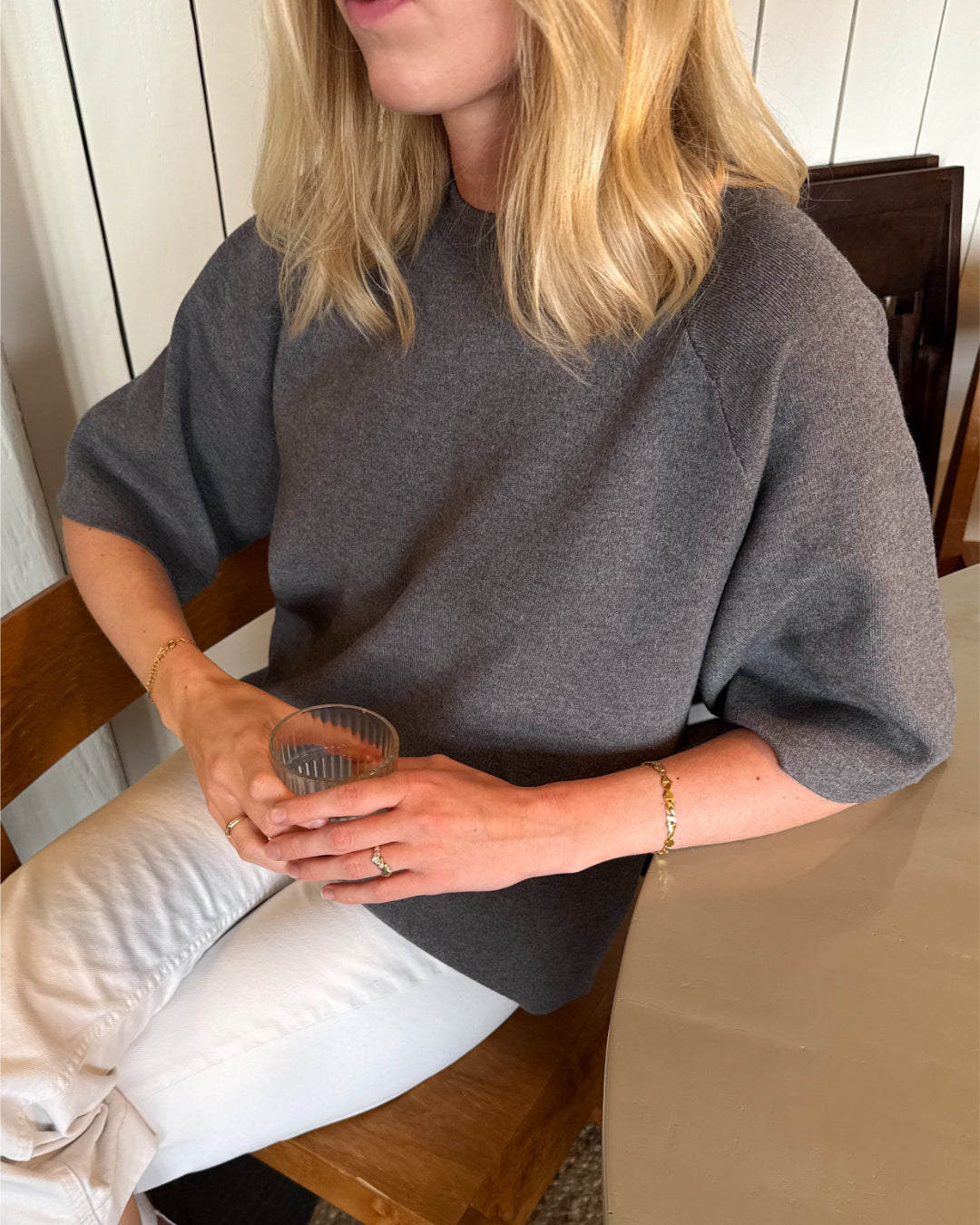 Modelfoto af pige der bærer Reynard strik t-shirt i grå, samt hvide bukser. Alt fra BySofieSønderby