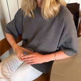 Modelfoto af pige der bærer Reynard strik t-shirt i grå, samt hvide bukser. Alt fra BySofieSønderby