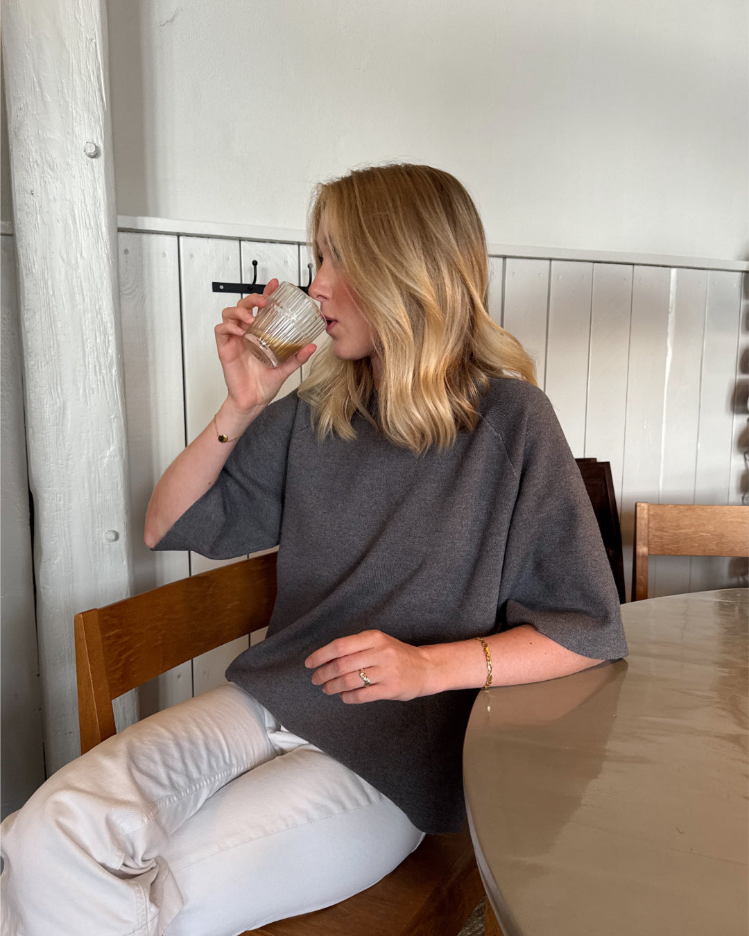 Modelfoto af pige der bærer Reynard strik t-shirt i grå, samt hvide bukser. Alt fra BySofieSønderby
