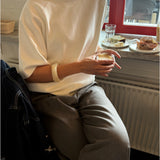 Modelfoto af pige der bærer Reynard strik t-shirt i hvid, samt grå bukser. Alt fra BySofieSønderby