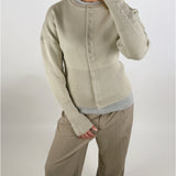 Stemningsbillede af pige der bærer en beige farvet RORY cardigan. Fra BySofieSønderby