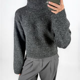 Modelfoto af pige i grå ROSANNA striktrøje med rullekrave, samt grå LISA bukser. Alt er fra BySofieSønderby.