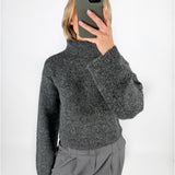 Modelfoto af pige i grå ROSANNA striktrøje med rullekrave, samt grå LISA bukser. Alt er fra BySofieSønderby.