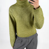 Modelfoto af pige i grøn ROSANNA striktrøje med rullekrave, samt grå LISA bukser. Alt er fra BySofieSønderby.