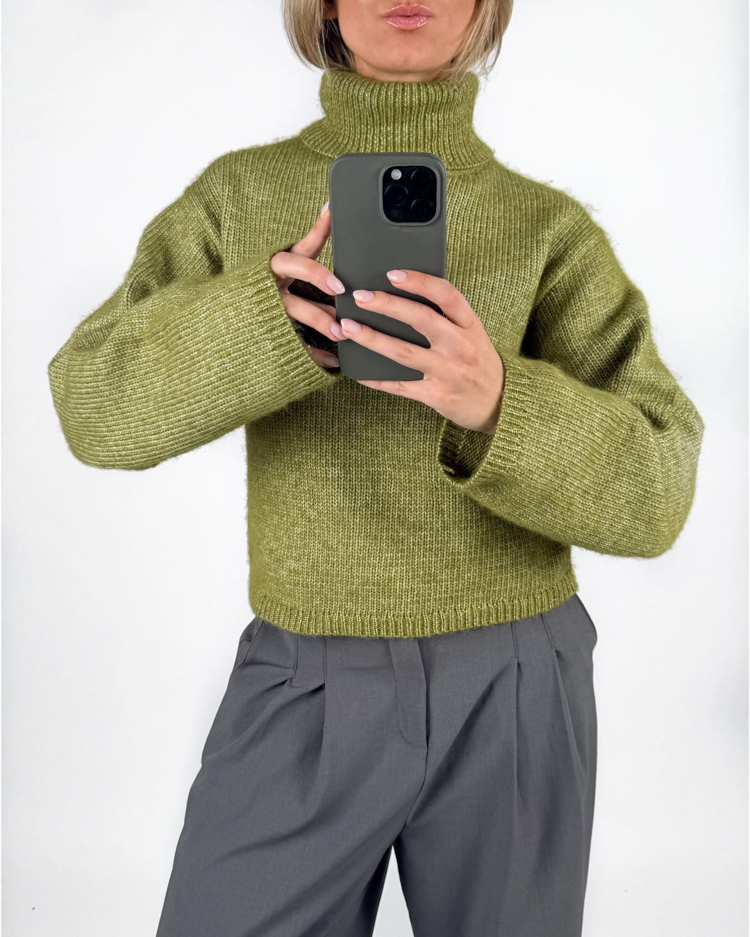 Modelfoto af pige i grøn ROSANNA striktrøje med rullekrave, samt grå LISA bukser. Alt er fra BySofieSønderby.