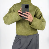 Modelfoto af pige i grøn ROSANNA striktrøje med rullekrave, samt grå LISA bukser. Alt er fra BySofieSønderby.