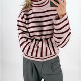 Modelfoto af pige i lyserødstribet ROSANNA striktrøje med rullekrave, samt grå LISA bukser. Alt er fra BySofieSønderby.