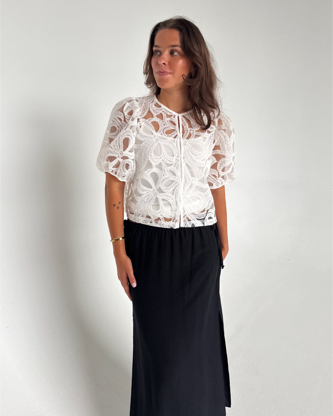 Modelfoto af pige som bærer en Rose bluse i hvid, samt en Breeze nederdel i navy. Alt fra By Sofie Sønderby