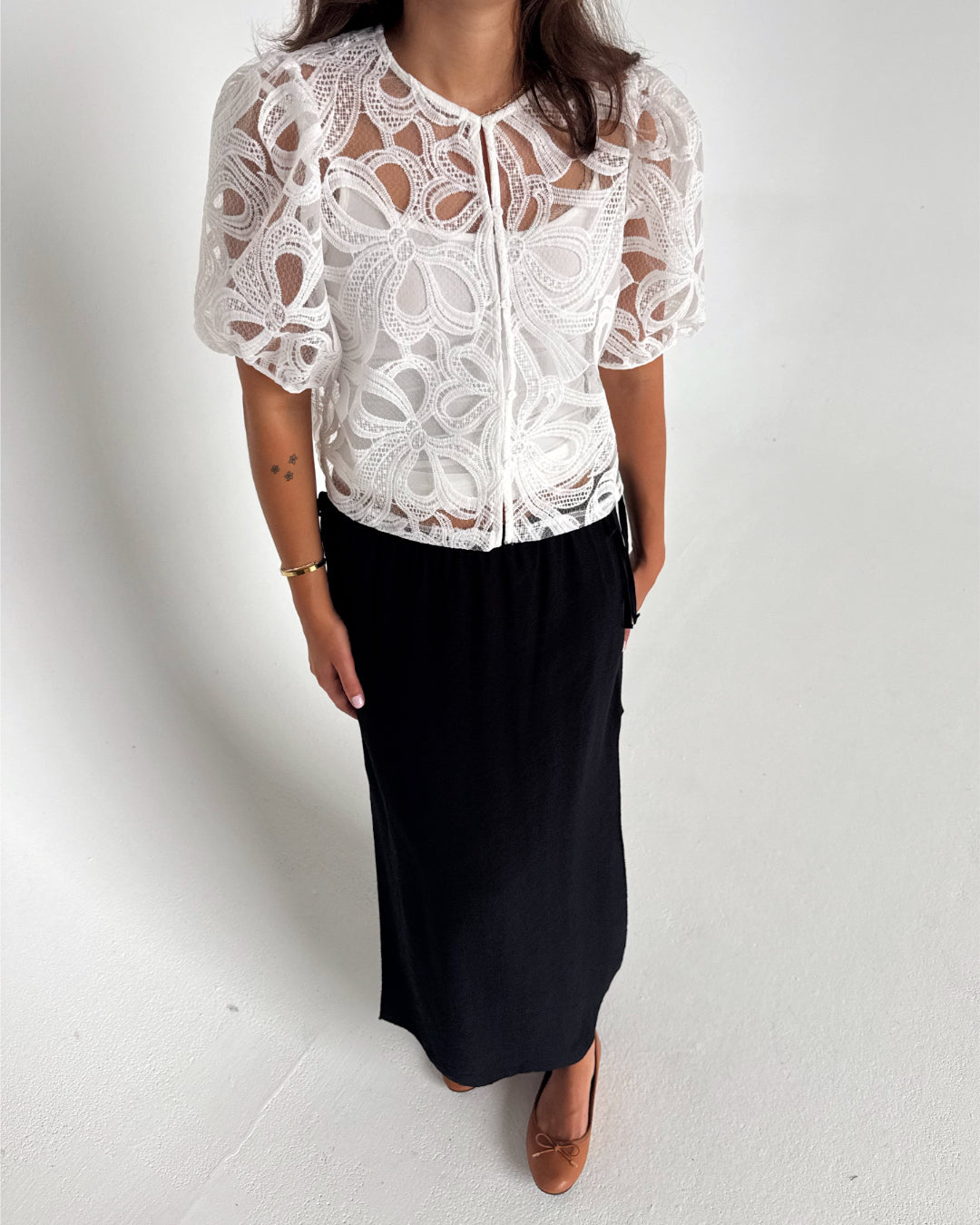 Modelfoto af pige som bærer en Rose bluse i hvid, samt en Breeze nederdel i navy. Alt fra By Sofie Sønderby
