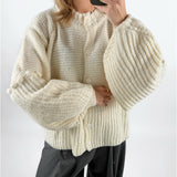 Modelfoto af pige med creme farvet RUTHIE strik cardigan, samt grå MILAN bukser. Set forfra. Alt er fra BySofieSønderby