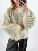 Modelfoto af pige med creme farvet RUTHIE strik cardigan, samt grå MILAN bukser. Set forfra. Alt er fra BySofieSønderby