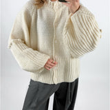 Modelfoto af pige med creme farvet RUTHIE strik cardigan, samt grå MILAN bukser. Set forfra. Alt er fra BySofieSønderby