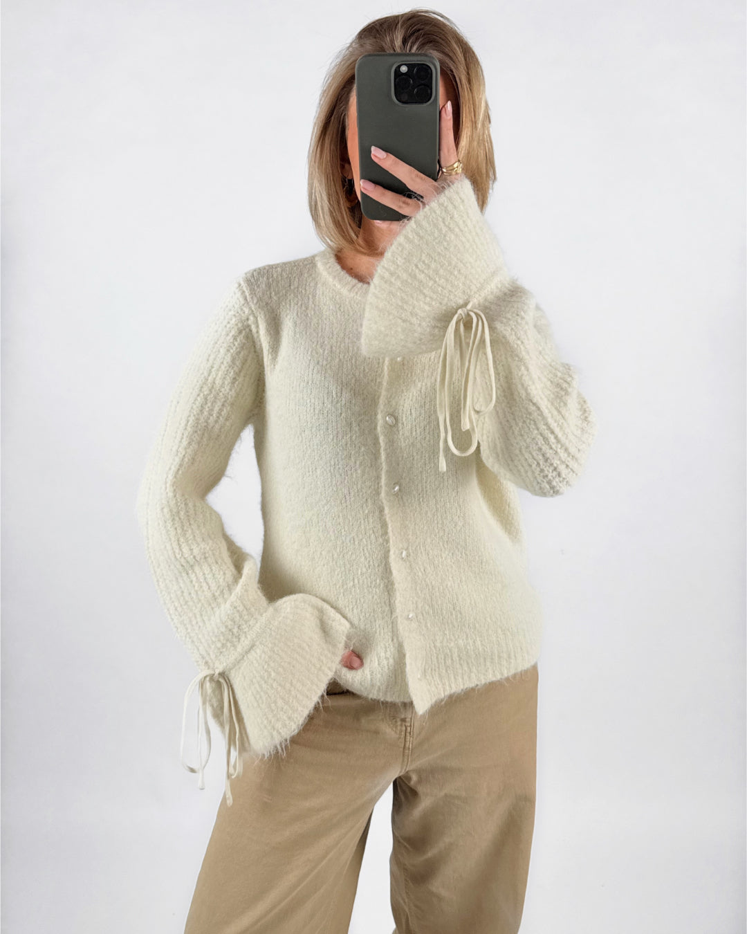 Modelfoto af pige med cremefarvet SALIKA strik cardigan, samt beige TOKYO jeans. Set forfra. Alt er fra BySofieSønderby