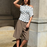 Modelbillede af SAMIRA one shoulder top, hvid og HARLEE shorts, brun. Fra BySofieSønderby