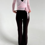 Modelfoto af pige i brune Sania yoga bukser og lyserød Luna wrap bluse. Fra BySofieSønderby