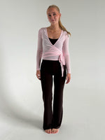 Modelfoto af pige i brune Sania yoga bukser og lyserød Luna wrap bluse. Fra BySofieSønderby