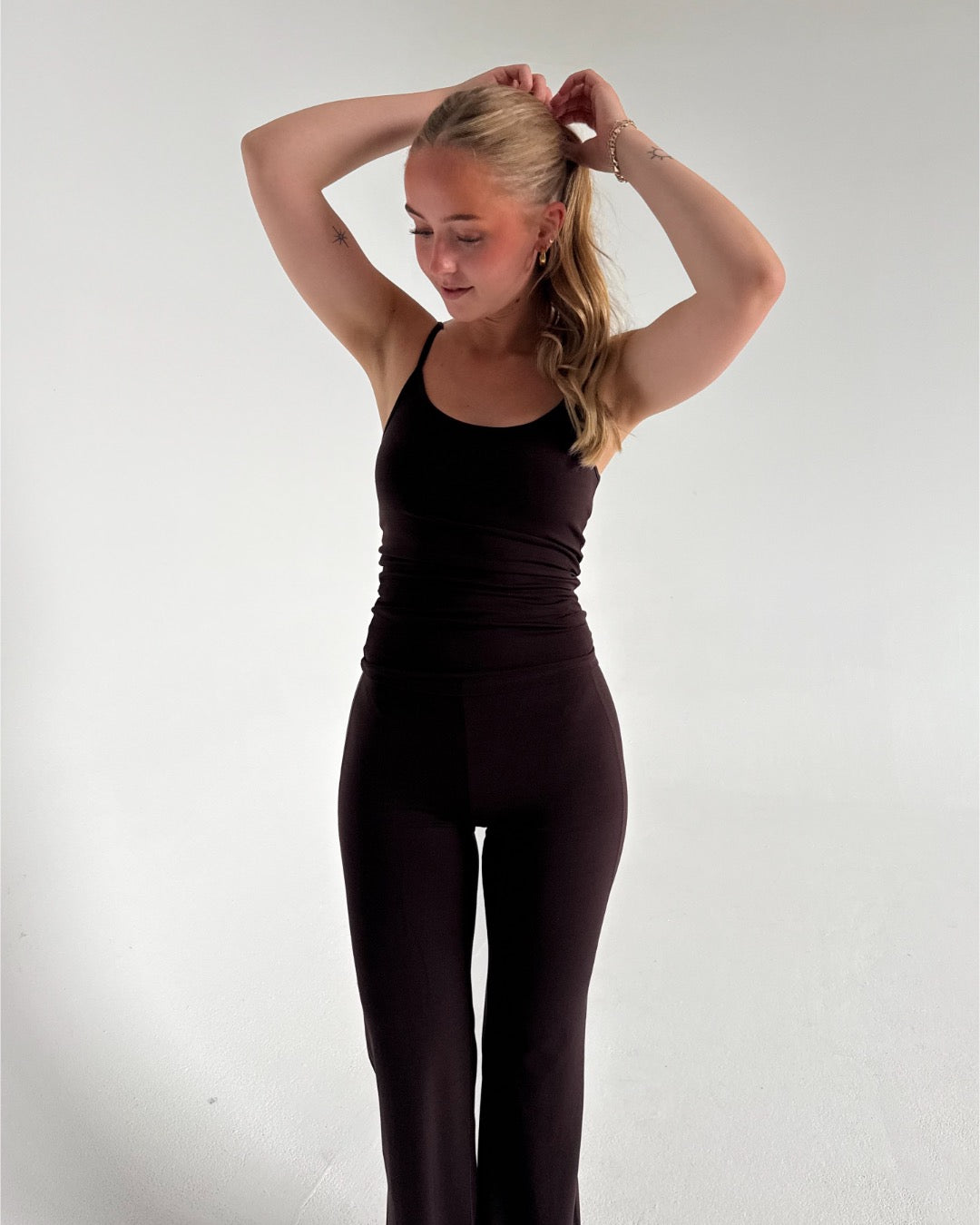 Modelfoto af pige i brun Sania yoga top og brune bukser. Fra BySofieSønderby