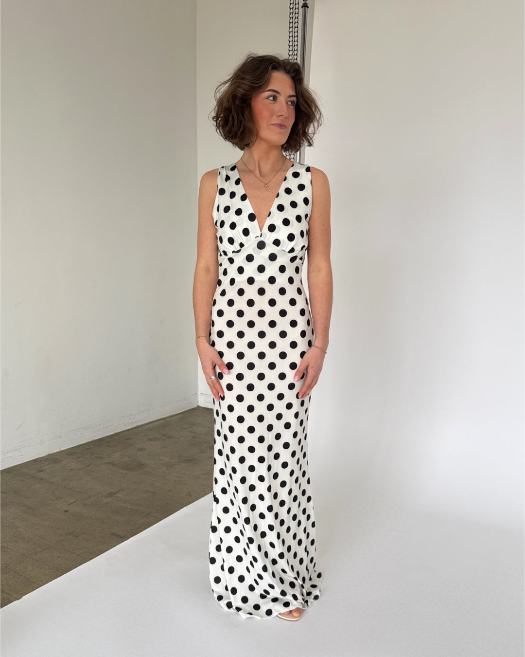 Modelbillede af hvid SAWYER kjole med sorte polka prikker. Set forfra. Fra BySofieSønderby
