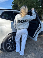 Modelfoto af pige, som bærer SNDRB sweatshirt, grå og NANNA jeans, hvid - alt fra BySofieSønderby