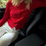 Modelfoto af pige i en rød Spina cardigan og hvide Nanna jeans. Alt er fra BySofieSønderby