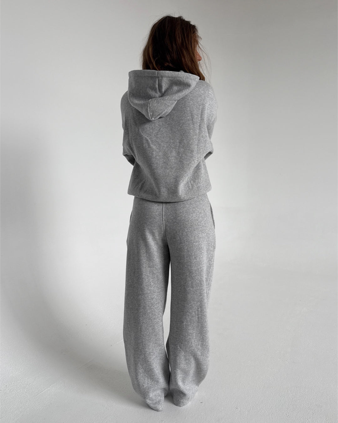 Modelfoto af pige som bærer en Studio Vesterbro bukser i grå, samt Studio Vesterbro hoodie i grå. Alt fra By Sofie Sønderby