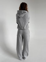 Modelfoto af pige som bærer en Studio Vesterbro bukser i grå, samt Studio Vesterbro hoodie i grå. Alt fra By Sofie Sønderby