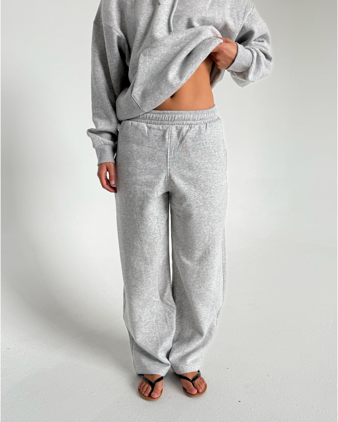 Modelfoto af pige som bærer en Studio Vesterbro bukser i grå, samt Studio Vesterbro hoodie i grå. Alt fra By Sofie Sønderby
