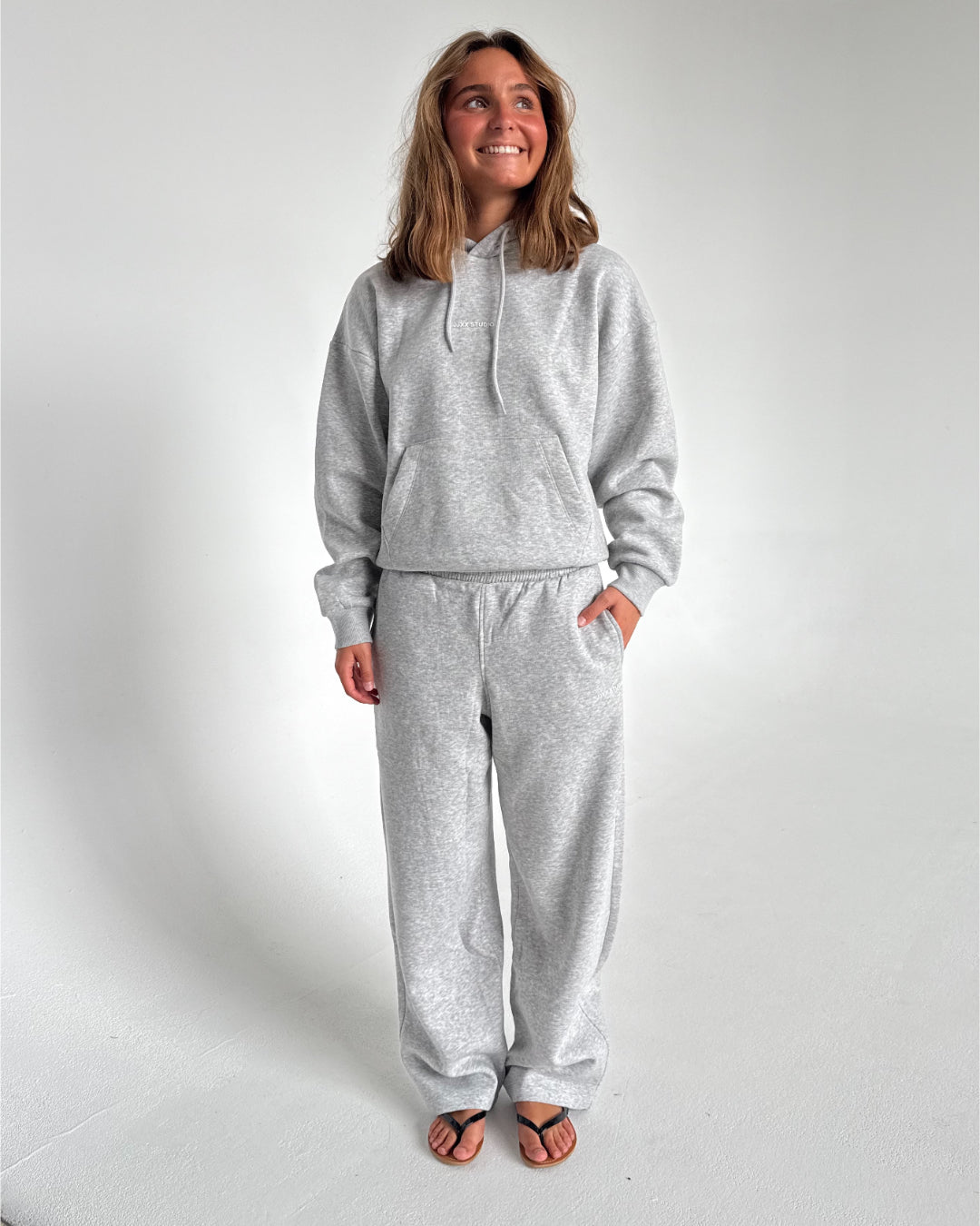 Modelfoto af pige som bærer en Studio Vesterbro bukser i grå, samt Studio Vesterbro hoodie i grå. Alt fra By Sofie Sønderby