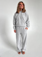 Modelfoto af pige som bærer en Studio Vesterbro bukser i grå, samt Studio Vesterbro hoodie i grå. Alt fra By Sofie Sønderby