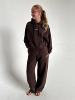 Modelfoto af pige som bærer en Studio Vesterbro hoodie i brun, samt Studio Vesterbro bukser i brun. Alt fra By Sofie Sønderby