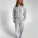 Modelfoto af pige som bærer en Studio Vesterbro hoodie i grå, samt Studio Vesterbro bukser i grå. Alt fra By Sofie Sønderby