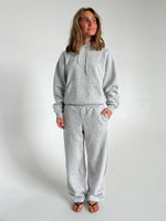 Modelfoto af pige som bærer en Studio Vesterbro hoodie i grå, samt Studio Vesterbro bukser i grå. Alt fra By Sofie Sønderby