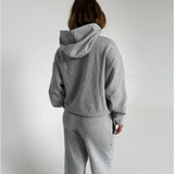 Modelfoto af pige som bærer en Studio Vesterbro hoodie i grå, samt Studio Vesterbro bukser i grå. Alt fra By Sofie Sønderby