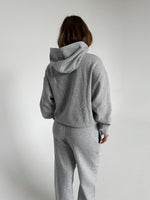 Modelfoto af pige som bærer en Studio Vesterbro hoodie i grå, samt Studio Vesterbro bukser i grå. Alt fra By Sofie Sønderby