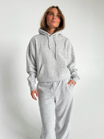 Modelfoto af pige som bærer en Studio Vesterbro hoodie i grå, samt Studio Vesterbro bukser i grå. Alt fra By Sofie Sønderby