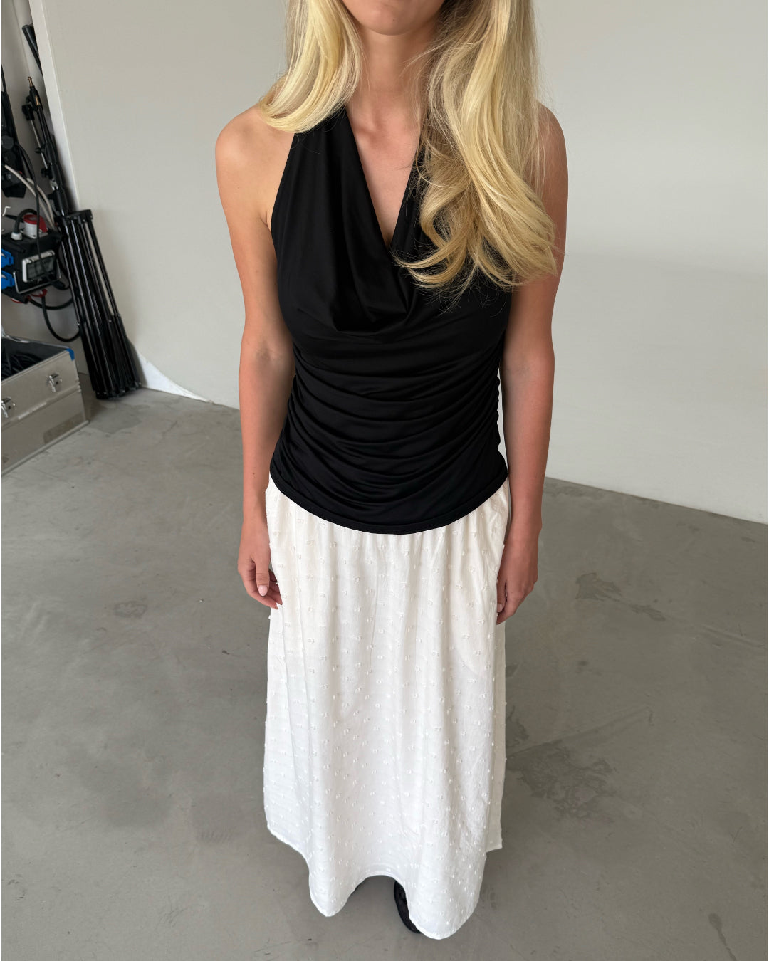 Modelfoto af pige som bærer en sort TAYLOR halterneck top, samt hvid nederdel. Alt er fra BySofieSønderby