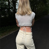 Modelfoto af pige i hvid Taytum vest og cremefarvede Adrianna jeans. Alt er fra BySofieSønderby