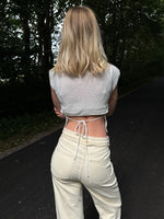 Modelfoto af pige i hvid Taytum vest og cremefarvede Adrianna jeans. Alt er fra BySofieSønderby