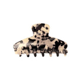 Hårspænde med leopardmønster, åbent og klar til brug, set mod en neutral hvid baggrund.