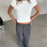 Modelfoto af pige som bærer hvid THORA offshoulder top og grå habitbukser . Alt er fra BySofieSønderby