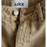 Knappen på et par beige bukser med lynlås er åben. Et mærke med teksten "JJXX" er synligt på indersiden.