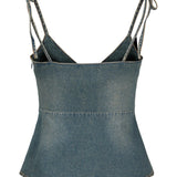En denim-top med tynde stropper, der er bundet i knuder ved skuldrene. Toppen har enkle syninger og fremstår i et lysblåt dongeristof.