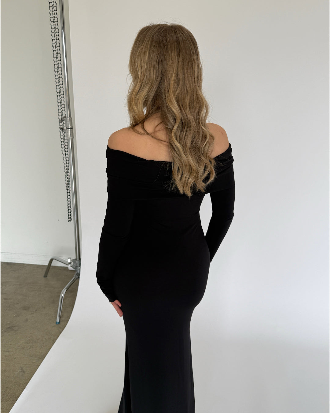 Modelbillede af sort XANDRA off shoulder kjole med lange ærmer. Set bagfra. Fra BySofieSønderby
