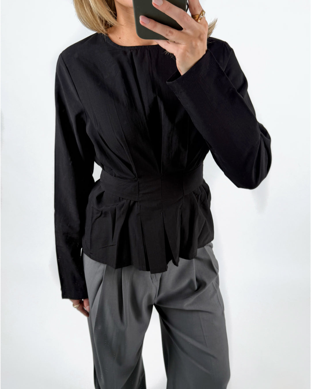 Modelfoto af pige med sort YUI bluse med sløjfedetalje på ryg, samt grå MILAN bukser. Set forfra. Alt er fra BySofieSønderby