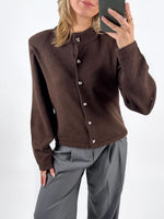 Modelfoto af pige med brun ZARI strik cardigan, samt grå MILAN bukser. Set forfra. Alt er fra BySofieSønderby