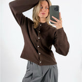 Modelfoto af pige med brun ZARI strik cardigan, samt grå MILAN bukser. Set forfra. Alt er fra BySofieSønderby