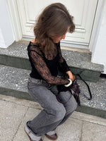 Modelfoto af pige i sort Zoya blondebluse og grå Nanna jeans. Alt er fra BySofieSønderby